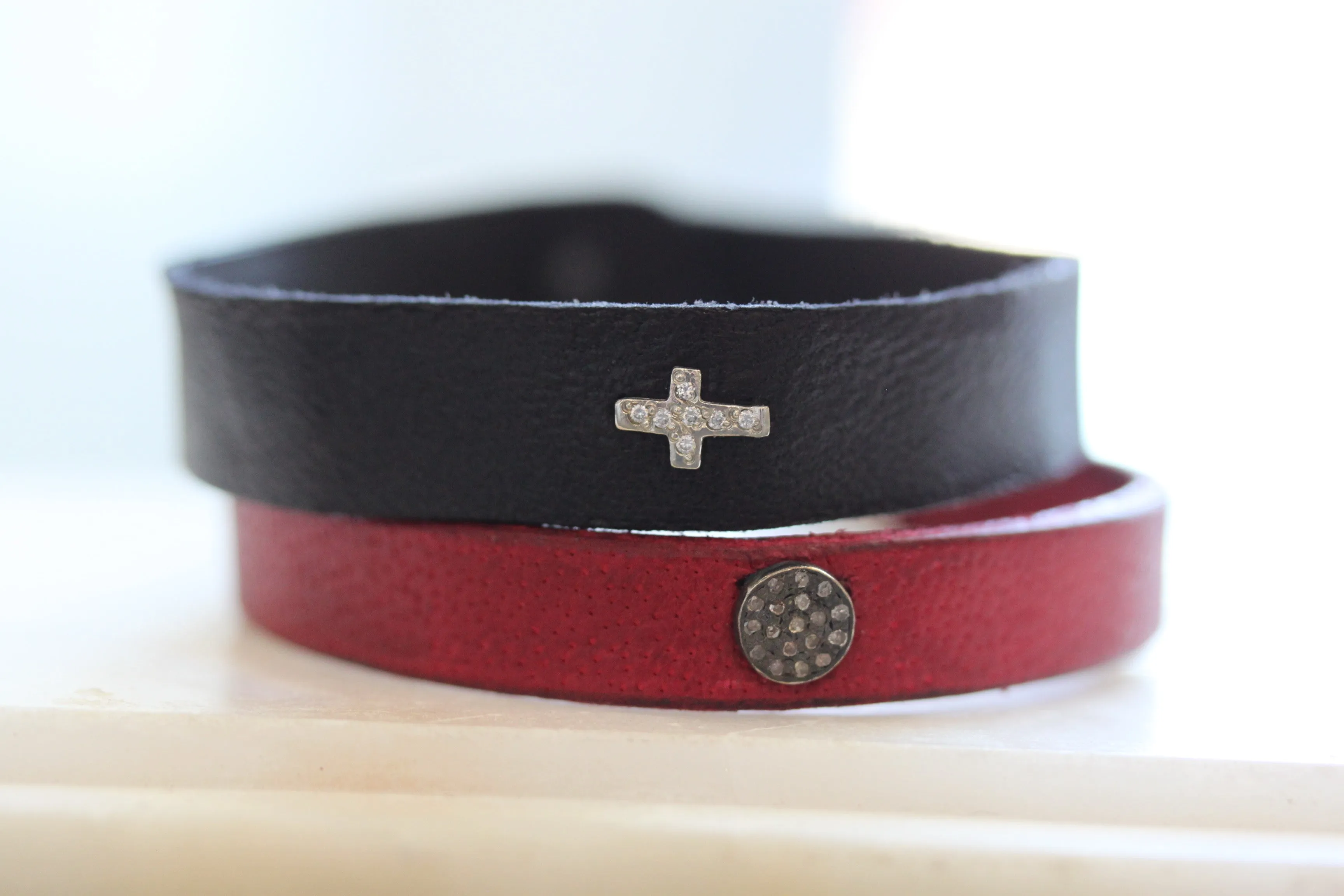 Pave Diamond Cross Leather Bracelet can be rewritten as Diamond Cross Leather Bracelet with Pave Detailing.